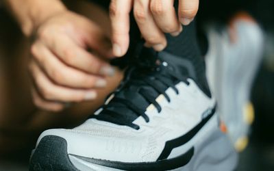 Man tying shoelaces before starting a workout